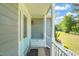 Charming covered porch with a light blue door, white railing, and a cozy spot for seating at 1413 Roy Averette Dr, Raleigh, NC 27603