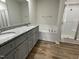 Bathroom featuring a soaking tub, shower stall, double vanity with granite counters, and modern fixtures at 148 Coharie Dr, Lillington, NC 27546