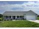 Charming single-story home with gray siding, manicured lawn, and attached two-car garage at 148 Coharie Dr, Lillington, NC 27546