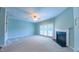 Open living room with a ceiling fan, fireplace, and sliding glass doors for natural light at 151 Braeside Ct, Cary, NC 27519