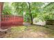 View of backyard features a red deck and small storage shed at 1510 Bungalow Ave, Durham, NC 27703