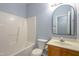 Cozy bathroom with tiled bathtub, toilet and mirror over wooden vanity at 1510 Bungalow Ave, Durham, NC 27703