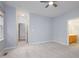 Spacious bedroom features plush carpet, neutral walls, ceiling fan, and a view to the ensuite bath at 1510 Bungalow Ave, Durham, NC 27703