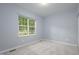Bright bedroom with large window, light gray carpet and pale blue walls at 1510 Bungalow Ave, Durham, NC 27703