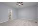 Bright bedroom with neutral walls, plush carpet, ceiling fan, and a view to the ensuite bath at 1510 Bungalow Ave, Durham, NC 27703