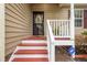 Close up of the front porch with red stairs, white railings, and ADT security sign at 1510 Bungalow Ave, Durham, NC 27703