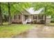 Charming home's exterior boasts colorful flowers, lush lawn, and a welcoming front porch at 1510 Bungalow Ave, Durham, NC 27703