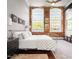 Bright bedroom boasts brick accent wall, oversized windows and dark wood floors at 1535 Caraleigh Mills Ct # 111, Raleigh, NC 27603