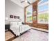 Bright bedroom boasts brick accent wall, oversized windows and dark wood floors at 1535 Caraleigh Mills Ct # 111, Raleigh, NC 27603