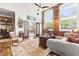 Spacious living room with large windows, brick accent wall, and hardwood floors at 1535 Caraleigh Mills Ct # 111, Raleigh, NC 27603