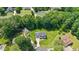 Aerial view of a home with mature trees, lush lawns, and a peaceful neighborhood setting at 1605 Baneberry Ct, Willow Springs, NC 27592