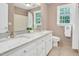Bright bathroom featuring dual sinks, a shower, a toilet, and a large window for ample natural light at 1605 Baneberry Ct, Willow Springs, NC 27592