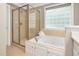 Bathroom featuring a walk-in shower, soaking tub, and natural light at 1605 Baneberry Ct, Willow Springs, NC 27592