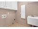 Functional laundry room with a utility sink, storage cabinets, and tile flooring for easy maintenance at 1605 Baneberry Ct, Willow Springs, NC 27592