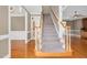 Carpeted staircase with wood railing, adjacent to an open foyer area at 1605 Baneberry Ct, Willow Springs, NC 27592