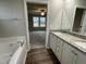 Bathroom featuring double vanity with granite countertops and separate bathtub at 170 Starry Sky Dr, Benson, NC 27504