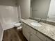 Bright bathroom featuring granite countertop, white cabinetry, and a tub shower at 170 Starry Sky Dr, Benson, NC 27504