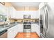 Cozy kitchen featuring white cabinets, stainless steel appliances, and tile countertops at 1700 Tiffany Bay Ct # 303, Raleigh, NC 27609