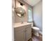 Charming bathroom with a gray vanity, modern round mirror, and updated lighting at 1809 Coltrane Ct, Raleigh, NC 27610