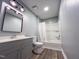 Bathroom with gray vanity, updated fixtures, and a shower-tub combination at 1809 Coltrane Ct, Raleigh, NC 27610
