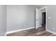 Simple bedroom with neutral walls, wood-look flooring, and an open doorway at 1809 Coltrane Ct, Raleigh, NC 27610