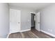Bedroom featuring neutral colors, closet, wood-look floors, and an open doorway at 1809 Coltrane Ct, Raleigh, NC 27610
