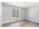 Bedroom featuring light gray walls, wood-look floors, and a bright window with views at 1809 Coltrane Ct, Raleigh, NC 27610