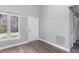 Entryway with wood-look floors, bright window, and a white six-panel front door at 1809 Coltrane Ct, Raleigh, NC 27610