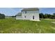 Rear exterior view of home showcasing white siding, backyard space, and a back door at 186 Coharie Dr, Lillington, NC 27546