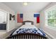 Comfortable bedroom with natural light, soft carpet, and colorful American and North Carolina flags at 2040 Pleasant Forest Way, Wake Forest, NC 27587