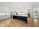 Bright and open kitchen with white cabinets, stainless steel appliances, and a large center island at 2040 Pleasant Forest Way, Wake Forest, NC 27587