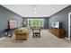 Spacious living room with a large window, plush seating, carpet, and dark neutral colored walls at 2040 Pleasant Forest Way, Wake Forest, NC 27587