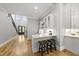 Stylish wet bar with seating and overhead cabinets offers seamless entertaining between the main living space and front entry at 2040 Pleasant Forest Way, Wake Forest, NC 27587