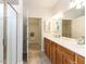 Bathroom featuring double sink vanity, tiled floors, walk-in shower, and access to closet at 207 Callum Pl, Cary, NC 27519