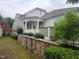 Charming home featuring a white picket fence, manicured landscaping, and an inviting patio area at 207 Callum Pl, Cary, NC 27519