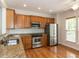 Modern kitchen with stainless steel appliances, granite countertops, and wood cabinets at 207 Callum Pl, Cary, NC 27519