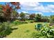 Lush backyard featuring a well-maintained lawn, a charming garden with mature trees and flowering plants at 2128 Feather Ridge Dr, Holly Springs, NC 27540