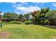 Expansive backyard featuring a large green lawn, garden beds with flowers and shrubs, and a fenced perimeter at 2128 Feather Ridge Dr, Holly Springs, NC 27540