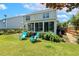 View of backyard featuring green grass, plants, fence, patio and sunroom at 2128 Feather Ridge Dr, Holly Springs, NC 27540