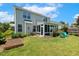 Spacious backyard featuring a screened in porch, garden area, lush green grass, and a well-maintained lawn at 2128 Feather Ridge Dr, Holly Springs, NC 27540
