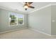 This sunny bedroom features neutral carpet, ceiling fan, and a large window at 2128 Feather Ridge Dr, Holly Springs, NC 27540
