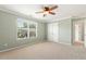 Carpeted bedroom with ceiling fan, large window, and closet with bi-fold doors at 2128 Feather Ridge Dr, Holly Springs, NC 27540
