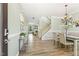 Elegant dining room with hardwood floors, chandelier, and staircase in a well-lit interior at 2128 Feather Ridge Dr, Holly Springs, NC 27540