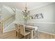Bright dining space with hardwood floors, chandelier, staircase, and neutral color palette at 2128 Feather Ridge Dr, Holly Springs, NC 27540