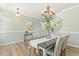 Well-appointed dining room with hardwood floors, a stylish chandelier, and neutral decor at 2128 Feather Ridge Dr, Holly Springs, NC 27540