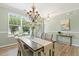 Charming dining room featuring hardwood floors, a modern chandelier, and ample natural light at 2128 Feather Ridge Dr, Holly Springs, NC 27540