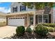 Attractive two-story home with brick accents, a two-car garage, and neat landscaping at 2128 Feather Ridge Dr, Holly Springs, NC 27540