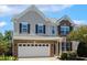 Charming two-story home with brick and vinyl siding, a two-car garage, and well-maintained landscaping at 2128 Feather Ridge Dr, Holly Springs, NC 27540