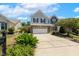 Traditional two-story home featuring a brick and vinyl exterior, a two-car garage, and a well-manicured front yard at 2128 Feather Ridge Dr, Holly Springs, NC 27540