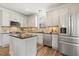 Bright kitchen features stainless steel appliances, granite countertops, and a central island with seating at 2128 Feather Ridge Dr, Holly Springs, NC 27540